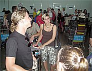 Tnzer und Musiker mit Grogepck beim Schlangestehen